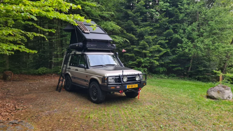 Land Rover Discovery met Fjällvila hardshell daktent UppTacka op een camping in het bos